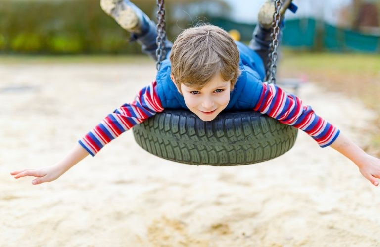 A child hanging onto a tire