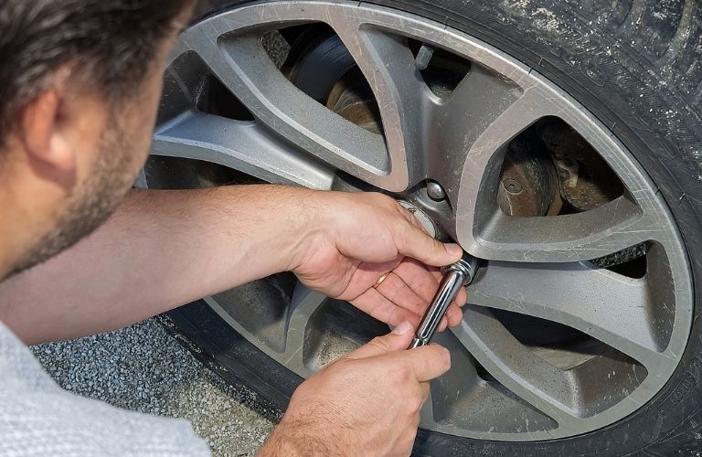 Image of a person using a wrench to loosen the nuts