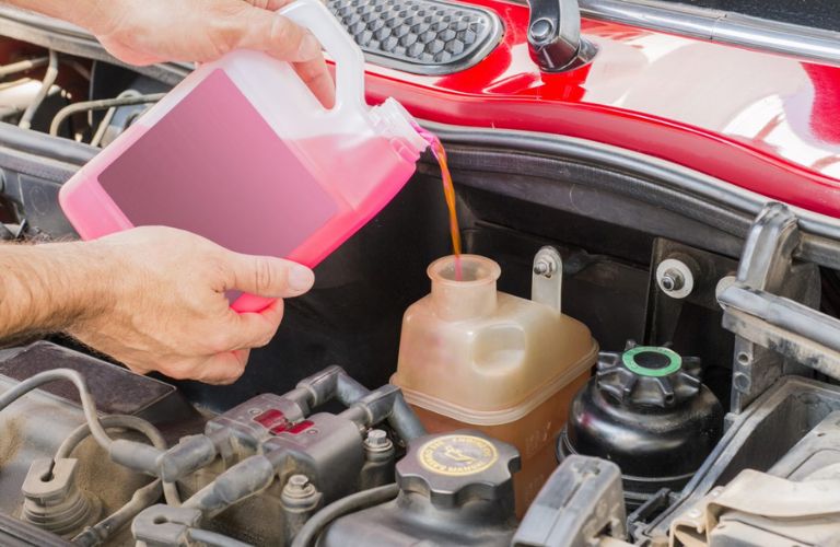 Man pouring oil into engine