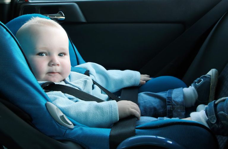 A baby is sitting in a car seat.