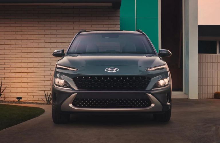 One green color 2022 Hyundai Kona is parked outside a building.