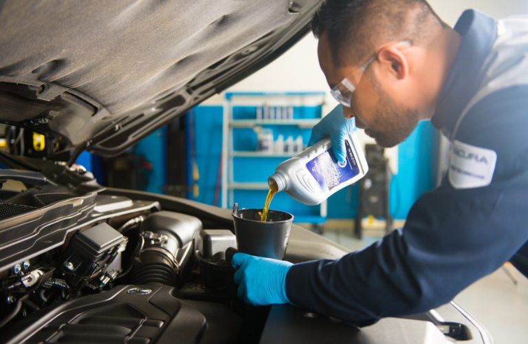 mechanic changing vehicle oil