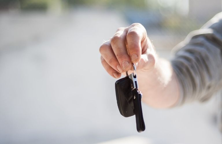 A person handing over a car key