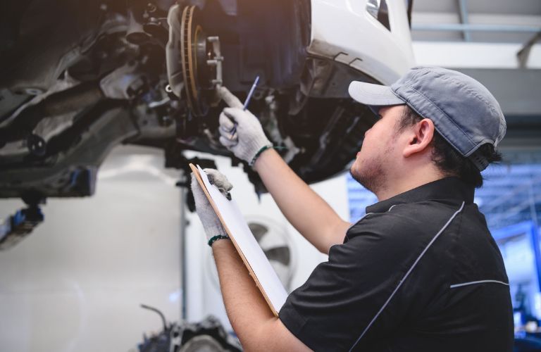 Service professional inspecting brakes of a vehicle