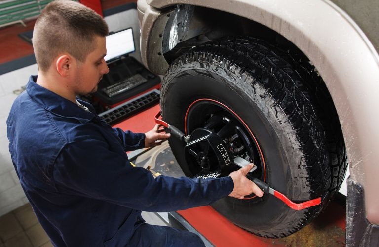 Car mechanic is doing wheel alignment.