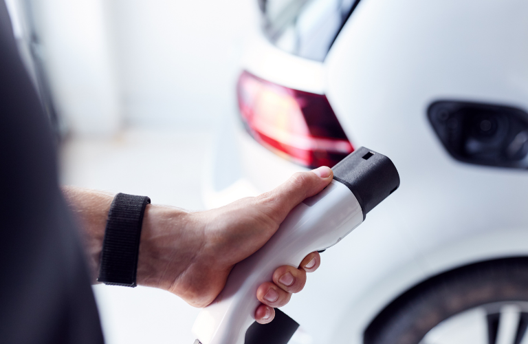 A man charging a vehicle