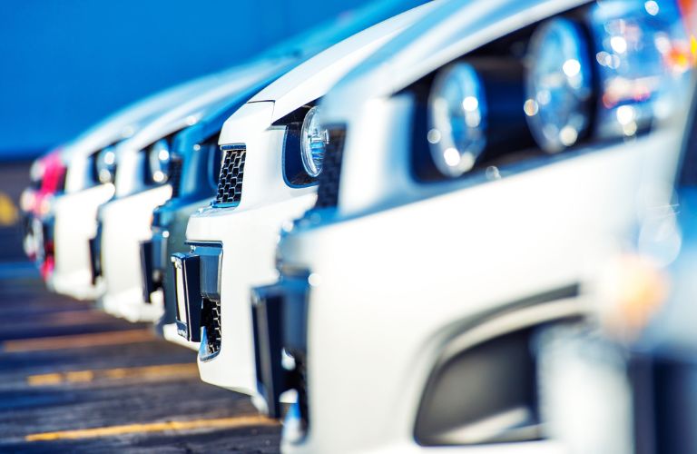 Close-up of bonnets and headlights of vehicles for sale at a dealership